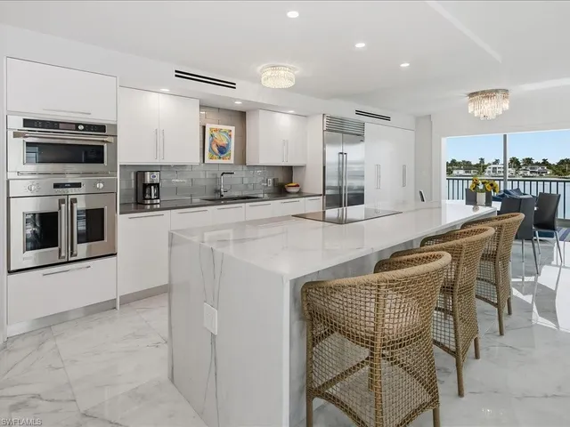 a kitchen with stainless steel appliances granite countertop a stove top oven a sink dishwasher a dining table and chairs