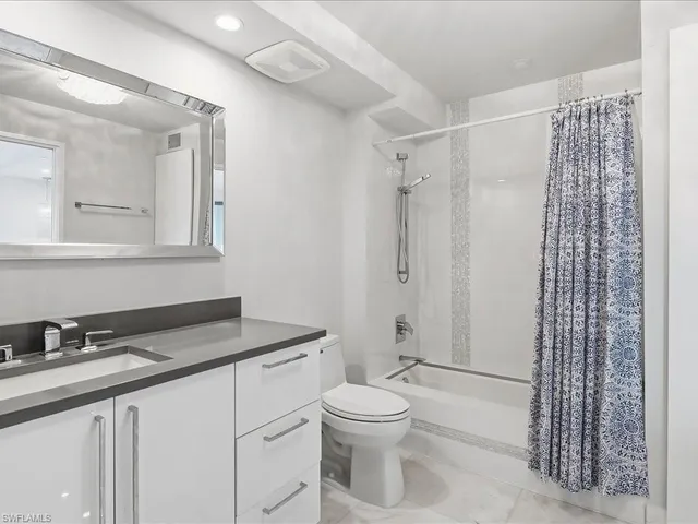 a bathroom with a granite countertop sink toilet a mirror a vanity and shower