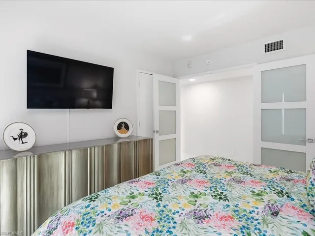 a bedroom with a bed and a flat screen tv