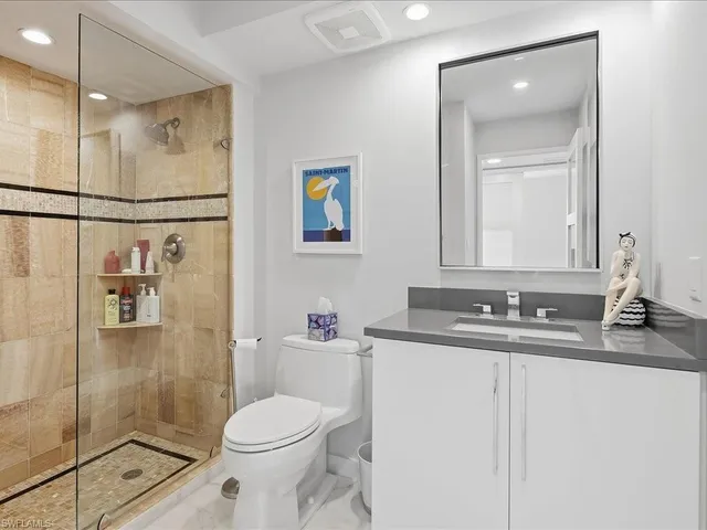 a bathroom with a granite countertop sink toilet and shower