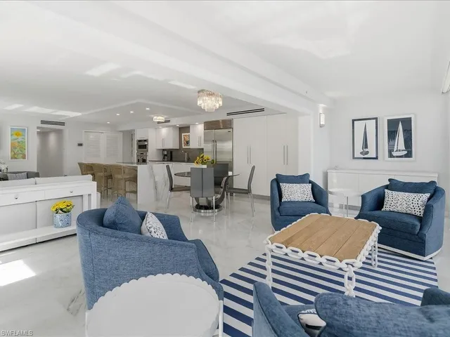 a living room with furniture and a view of kitchen