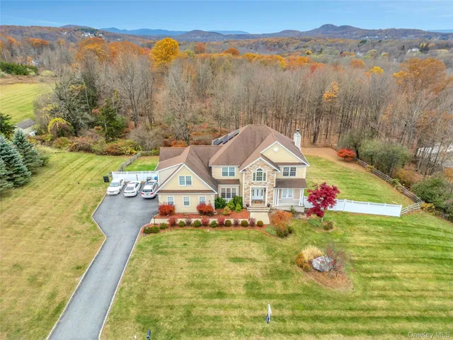 a view of a house with a big yard and large trees