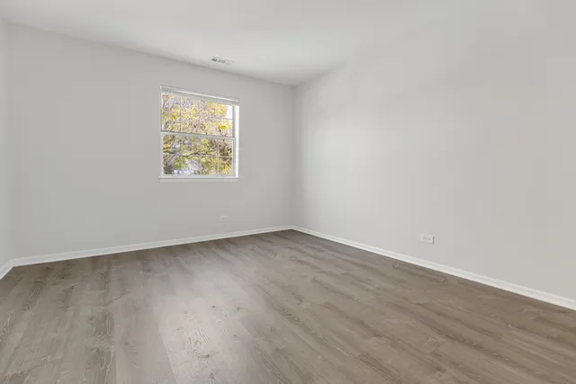 an empty room with wooden floor and a window