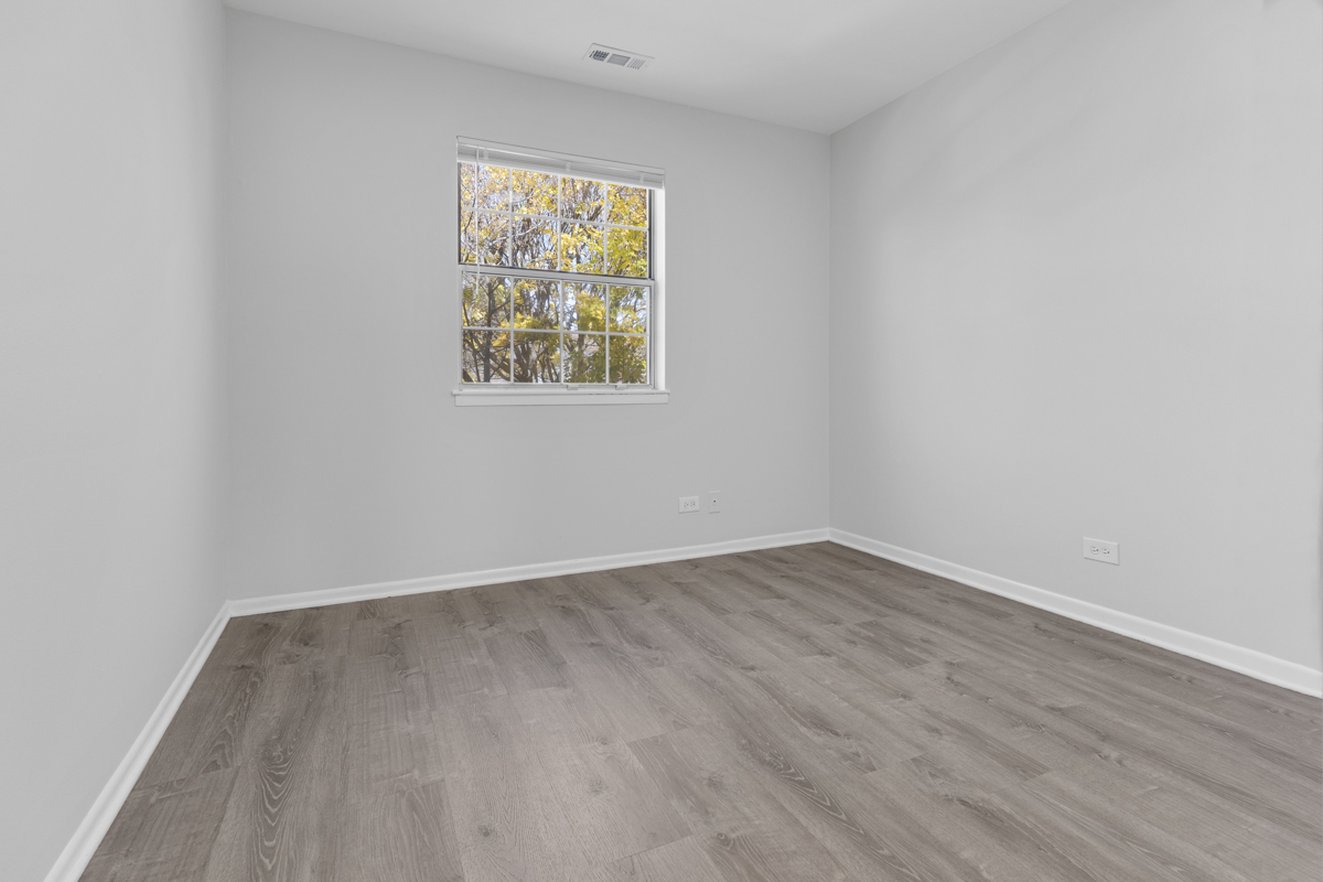 40 South Victoria Lane, Unit G Streamwood, IL 60107 - Photo 14 of 22 an empty room with wooden floor and window