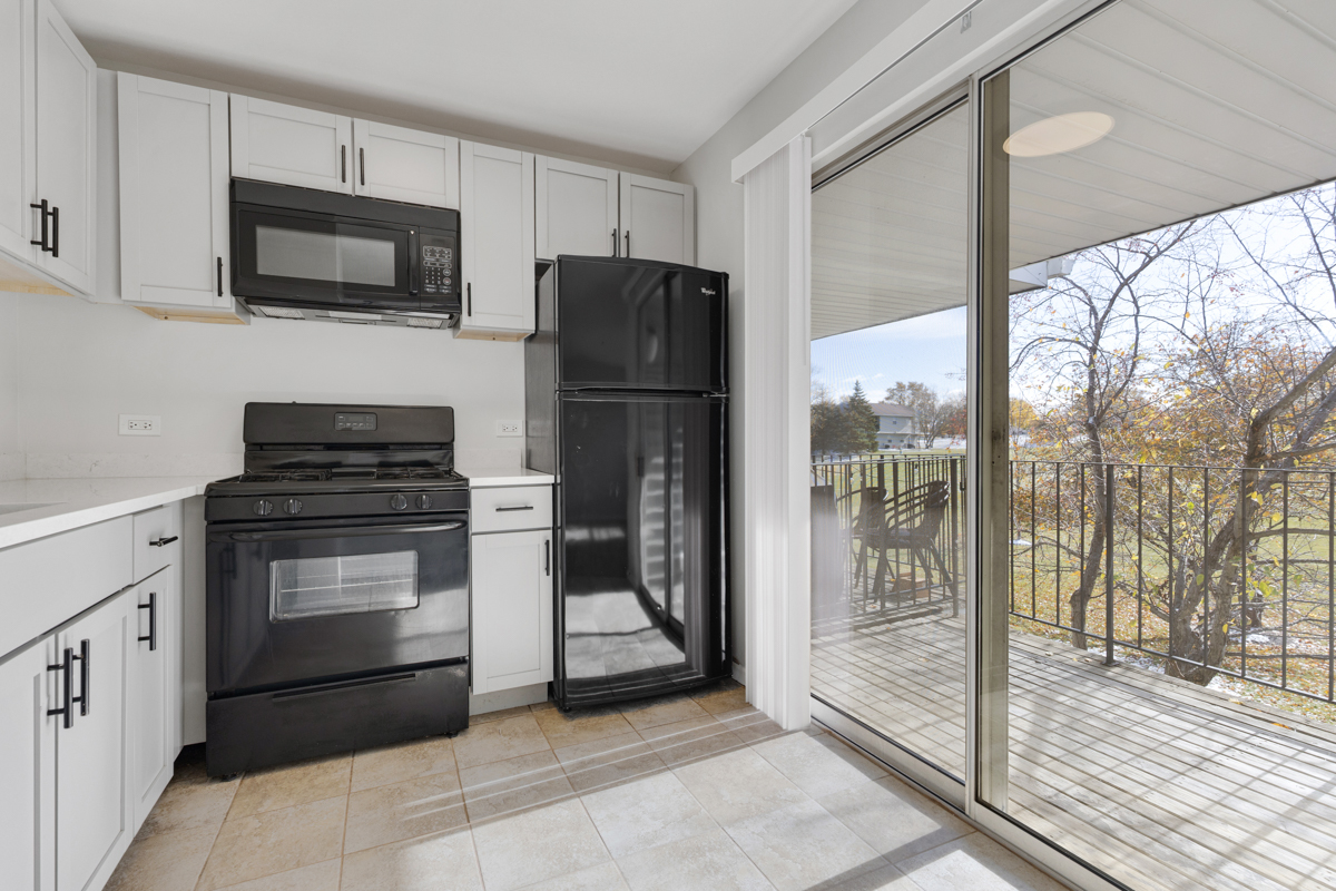 40 South Victoria Lane, Unit G Streamwood, IL 60107 - Photo 7 of 22 a kitchen with a refrigerator stove and microwave