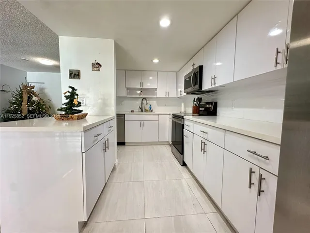 a kitchen with granite countertop a stove top oven sink and cabinets