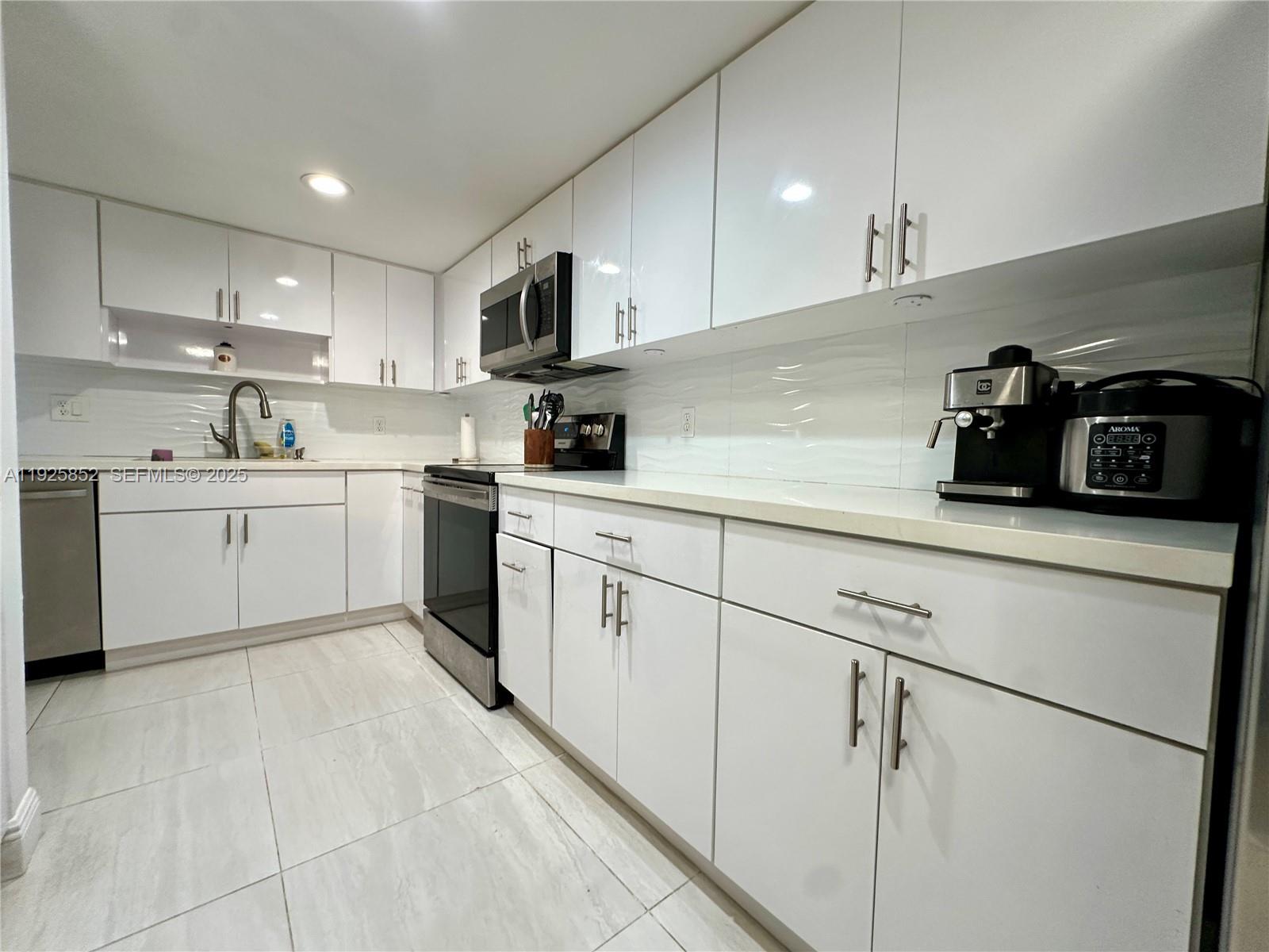 8091 Northwest 12th Street, Unit A Margate, FL 33063 - Photo 14 of 70 a kitchen with a sink white cabinets and white appliances