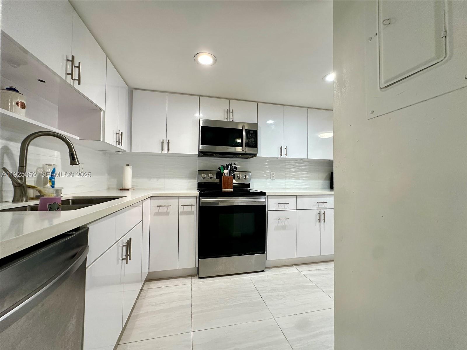 8091 Northwest 12th Street, Unit A Margate, FL 33063 - Photo 15 of 70 a kitchen with granite countertop a stove top oven sink and cabinets