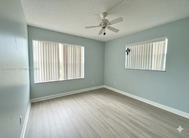 a spacious bedroom with a bed and a flat screen television