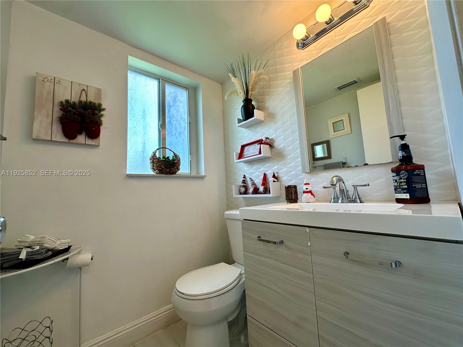 8091 Northwest 12th Street, Unit A Margate, FL 33063 - Photo 20 of 70 a bathroom with a toilet sink and mirror