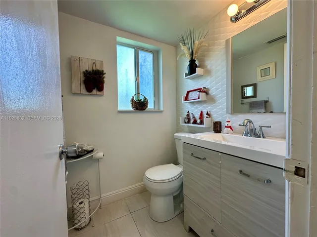 a bedroom with a bed television on desk and a window