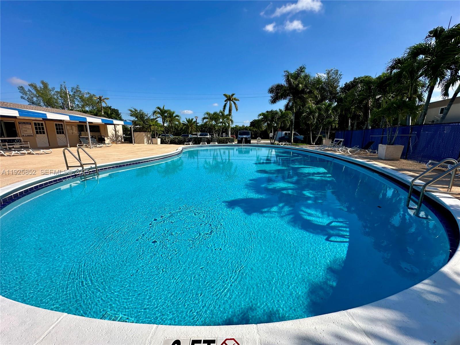 8091 Northwest 12th Street, Unit A Margate, FL 33063 - Photo 63 of 70 a view of a swimming pool with an outdoor seating and trees in the background