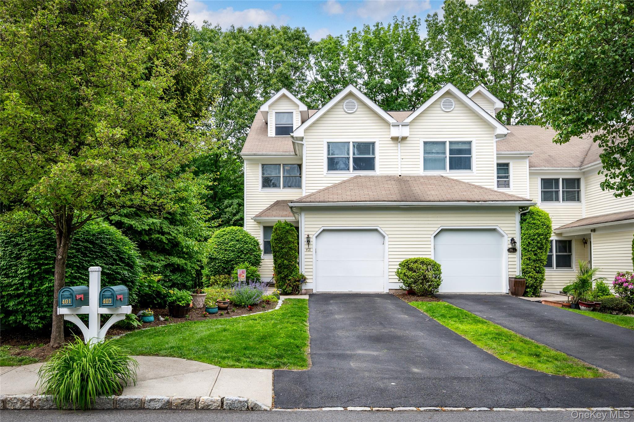 a front view of a house with a garden and plants