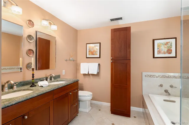 a bathroom with a bathtub sink mirror vanity and toilet