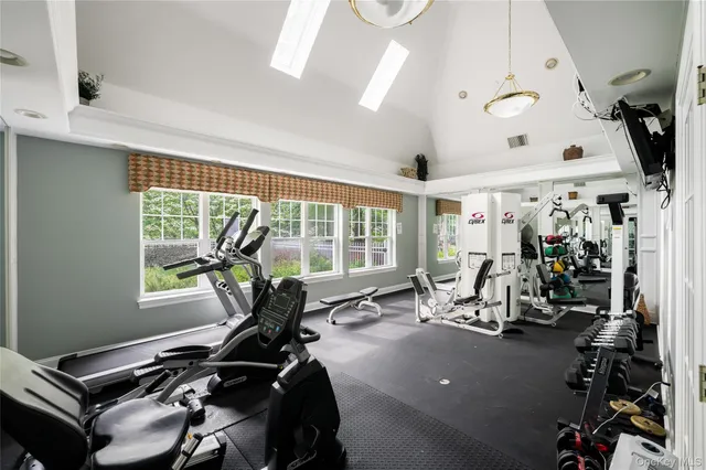 a room with gym equipment and large windows