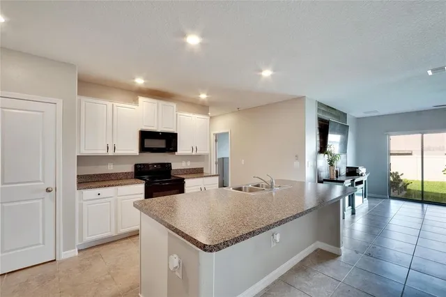 a kitchen with stainless steel appliances granite countertop a sink dishwasher stove and microwave with wooden floor