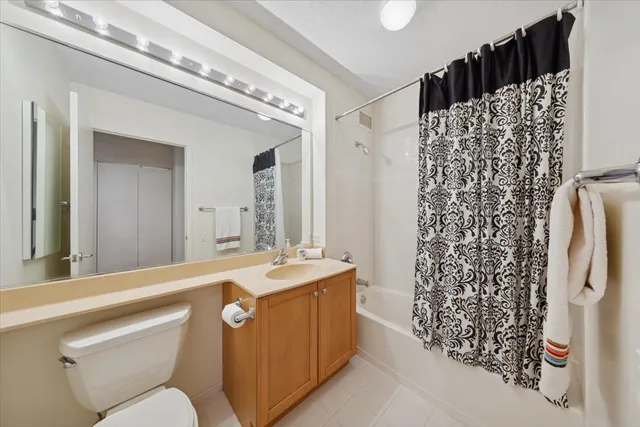 a bathroom with a sink a toilet a shower curtain and a mirror