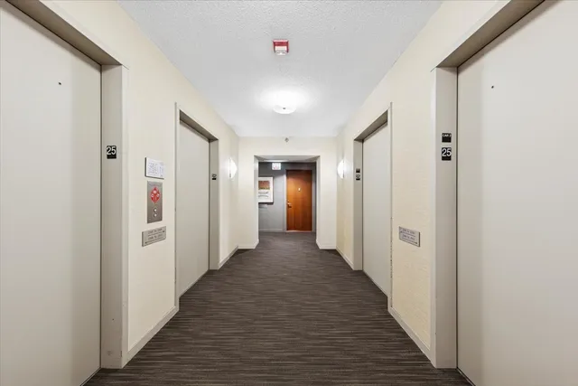 a view of a hallway with wooden floor and closet area