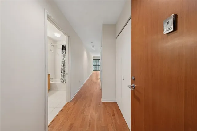 a view of a hallway with wooden floor and staircase
