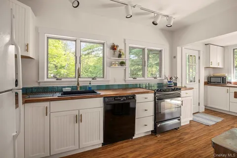a kitchen with granite countertop white cabinets and white appliances