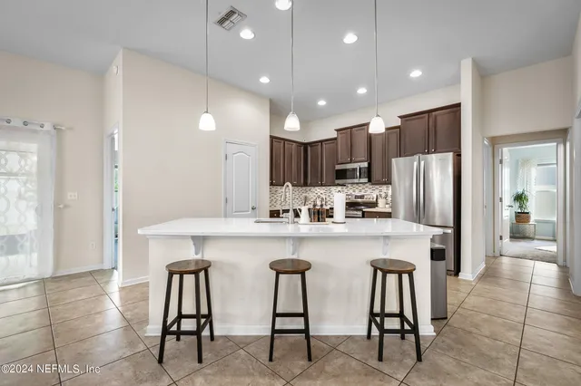 a kitchen with stainless steel appliances granite countertop a center island and a refrigerator