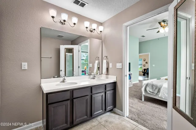 a en suite bathroom with a double vanity sink and a mirror