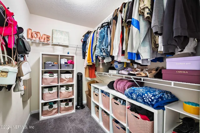a view of walk in closet with clothes and shoes