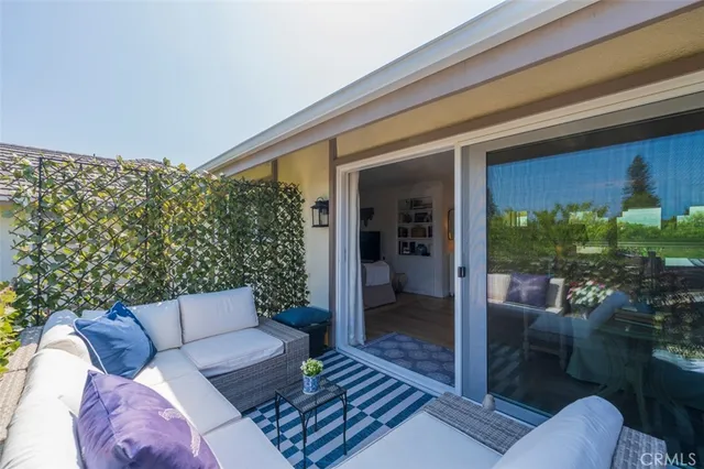 a view of a patio with couches chairs dining table and chairs with wooden floor