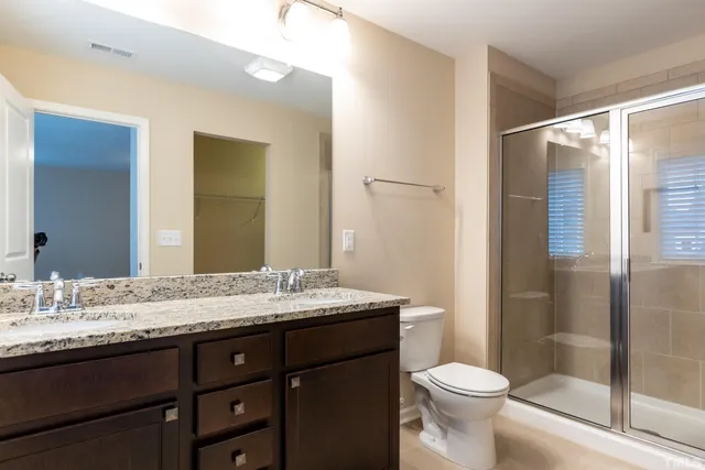 a bathroom with a granite countertop sink toilet and shower