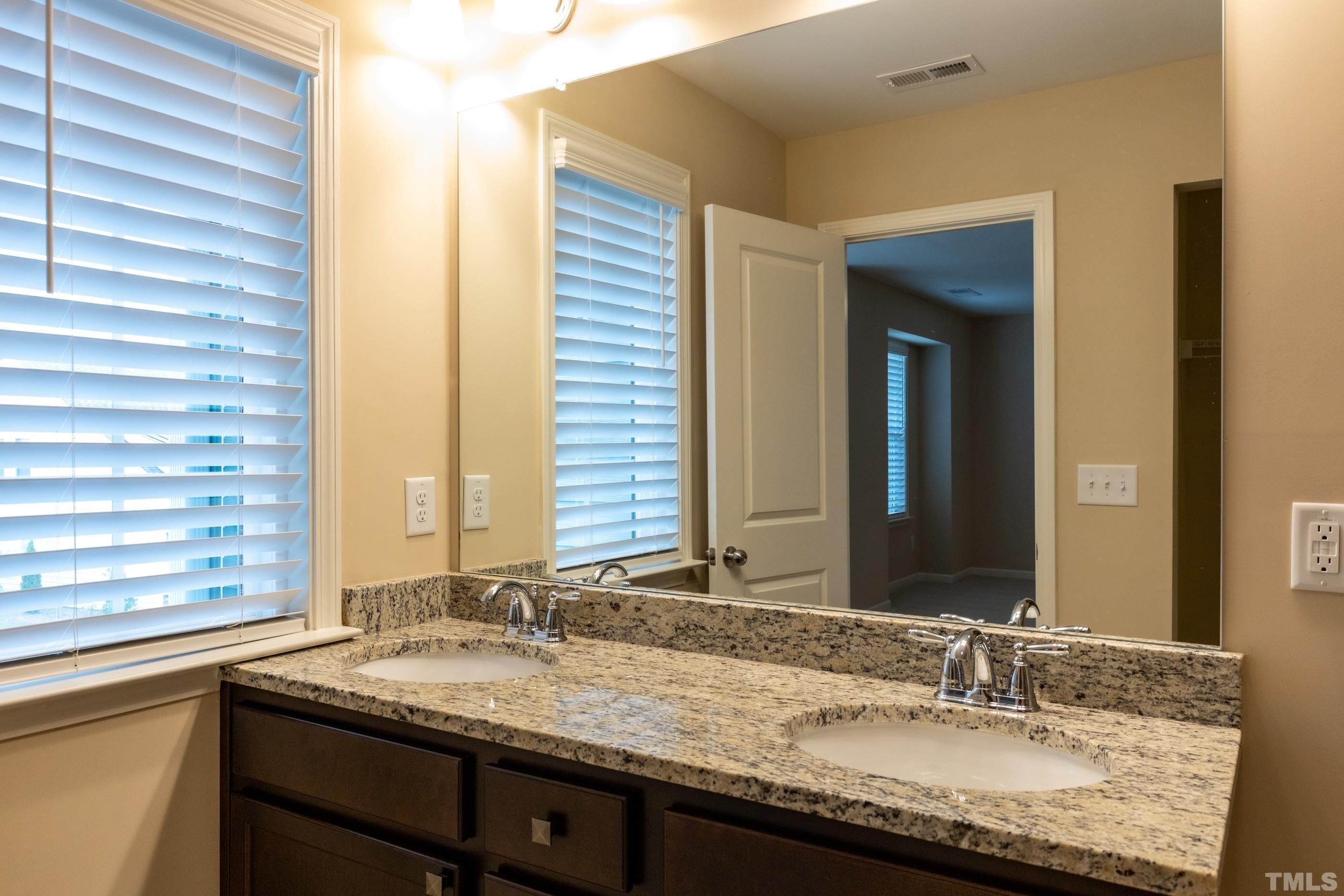 566 Chessie Station Apex, NC 27502 - Photo 20 of 29 a bathroom with a granite countertop sink and a mirror