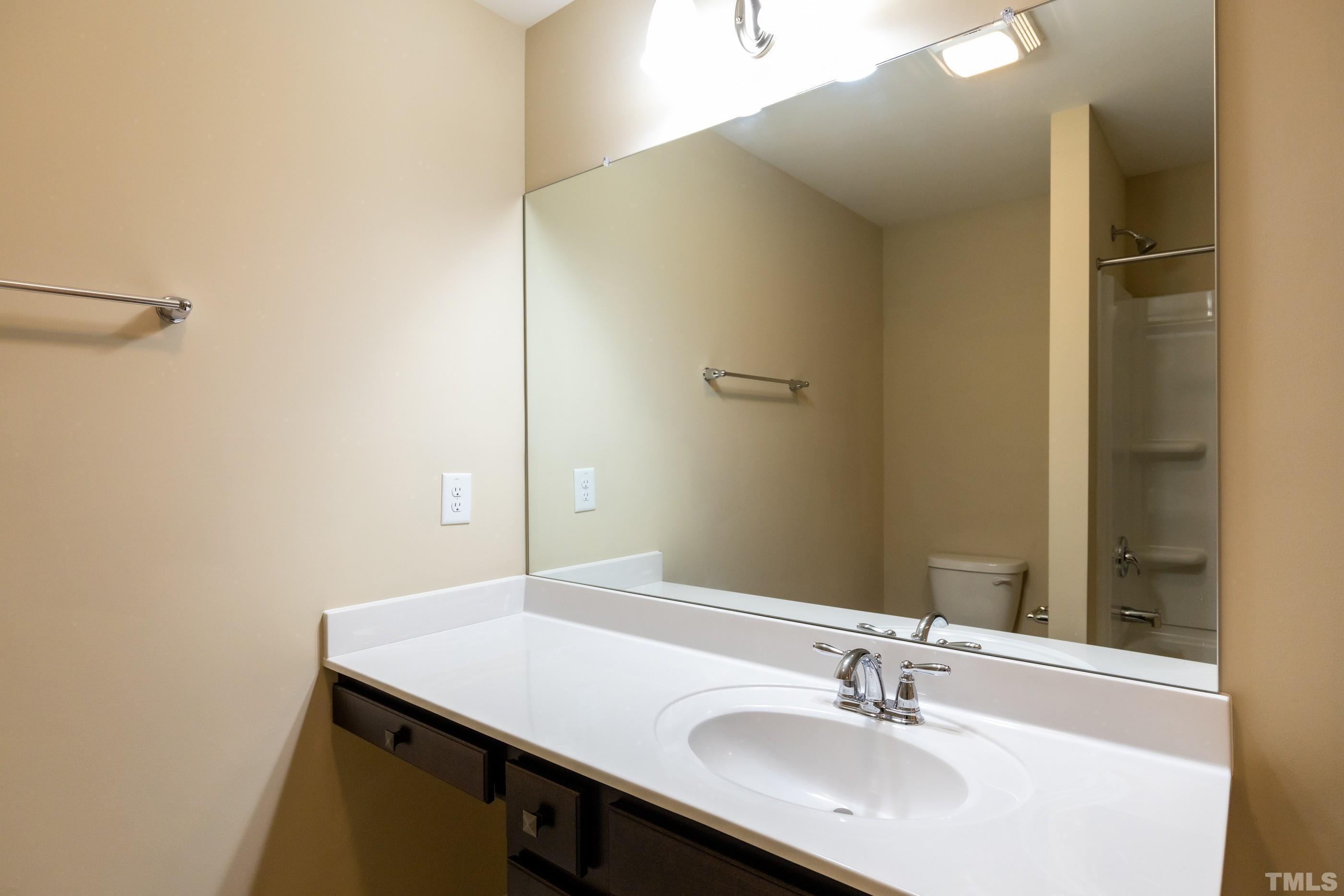 566 Chessie Station Apex, NC 27502 - Photo 25 of 29 a bathroom with a sink and a mirror