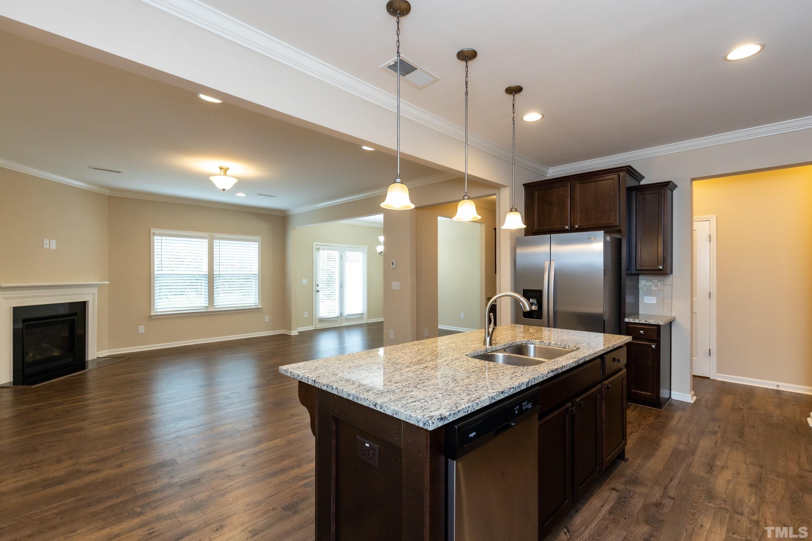 566 Chessie Station Apex, NC 27502 - Photo 3 of 29 a kitchen with stainless steel appliances granite countertop a refrigerator a sink a stove a dining table and chairs