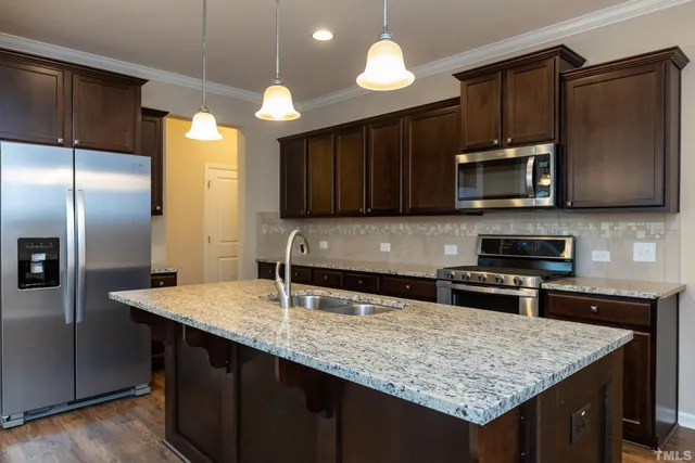 a kitchen with stainless steel appliances granite countertop a sink refrigerator and microwave