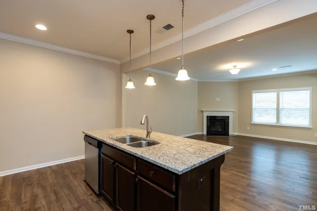 a kitchen with a sink chandelier and wooden floor