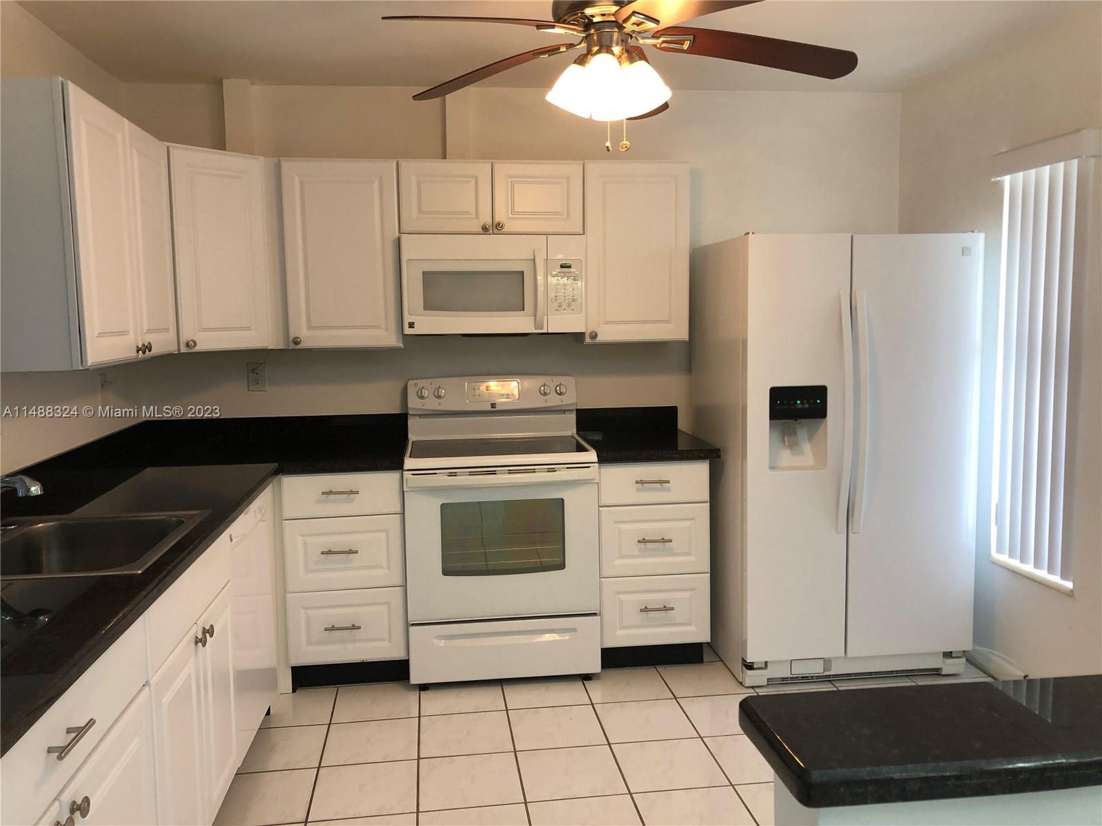 West Perrine Miami, FL 33157 - Photo 4 of 15 a kitchen with a refrigerator a stove a microwave and cabinets