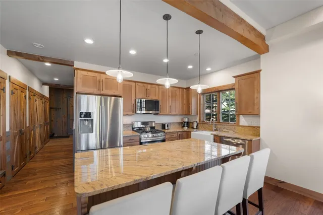 a kitchen with stainless steel appliances granite countertop a sink a refrigerator and a stove
