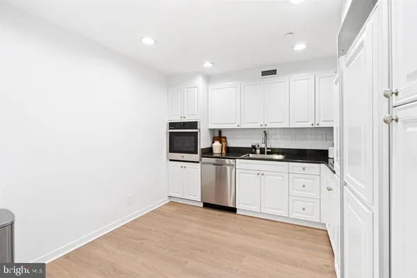 a kitchen with stainless steel appliances granite countertop a stove a sink and a microwave