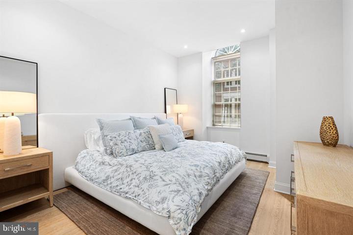 211 South 4th Street, Unit 104 Philadelphia, PA 19106 - Photo 22 of 45 a bedroom with a bed and wooden floor