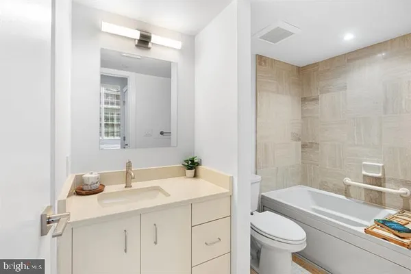 a bathroom with a sink toilet vanity tub and shower