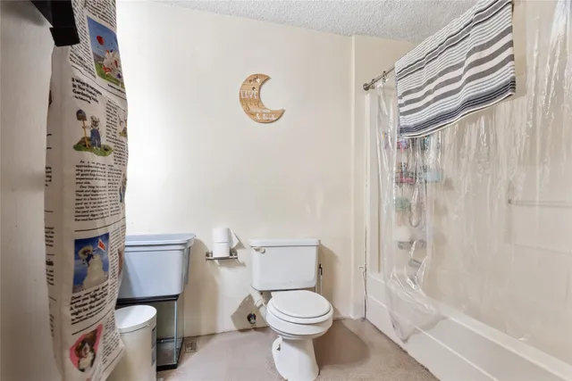 a white toilet sitting next to a bath tub and shower