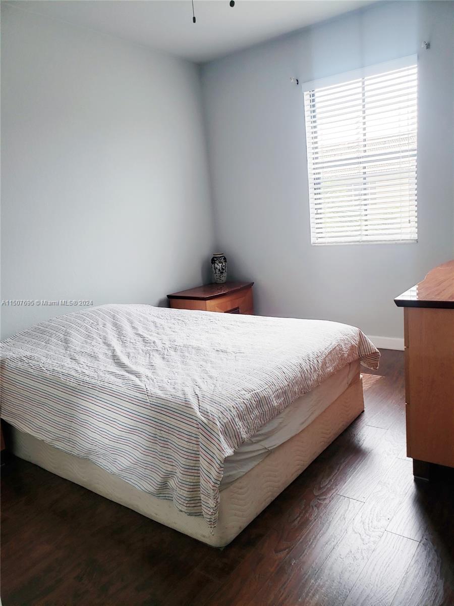 11343 Southwest 232nd Terrace Homestead, FL 33032 - Photo 22 of 35 a bedroom with a bed and wooden floor