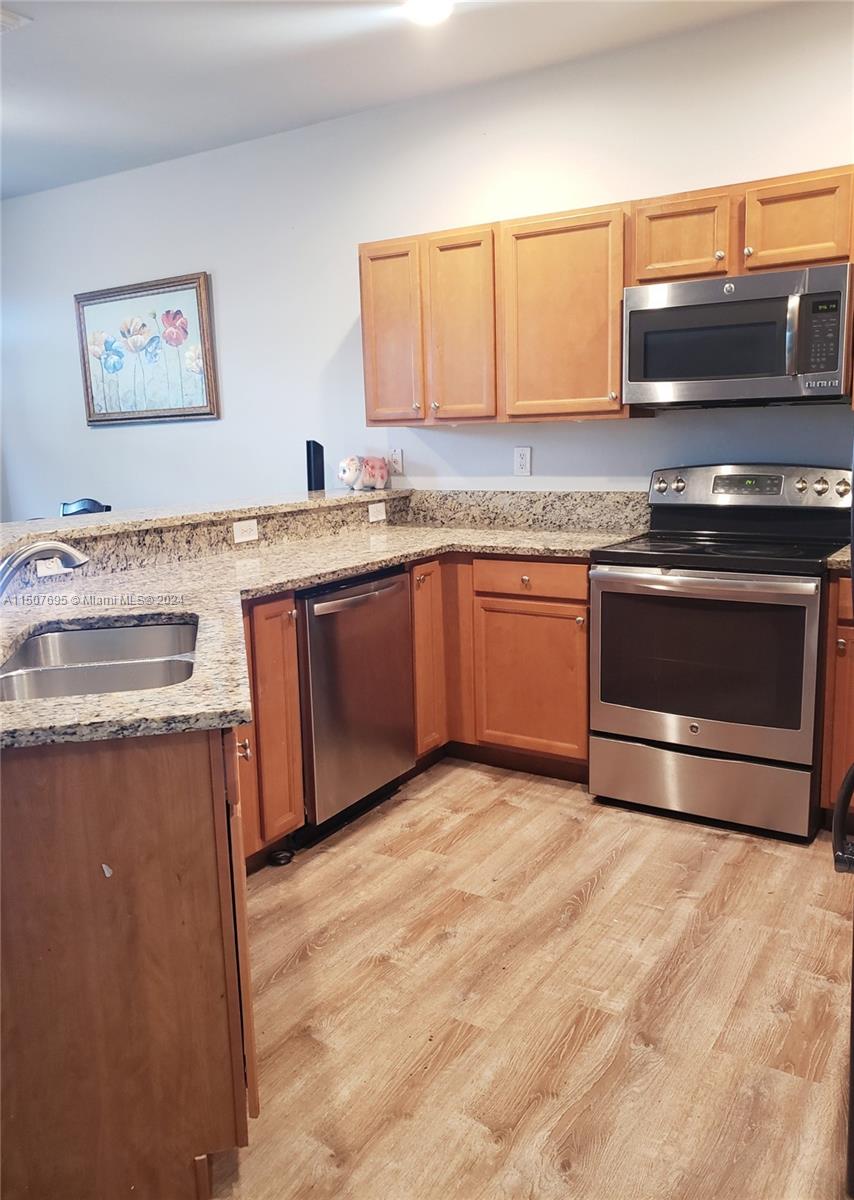 11343 Southwest 232nd Terrace Homestead, FL 33032 - Photo 8 of 35 a kitchen with stainless steel appliances granite countertop a stove a sink and a microwave