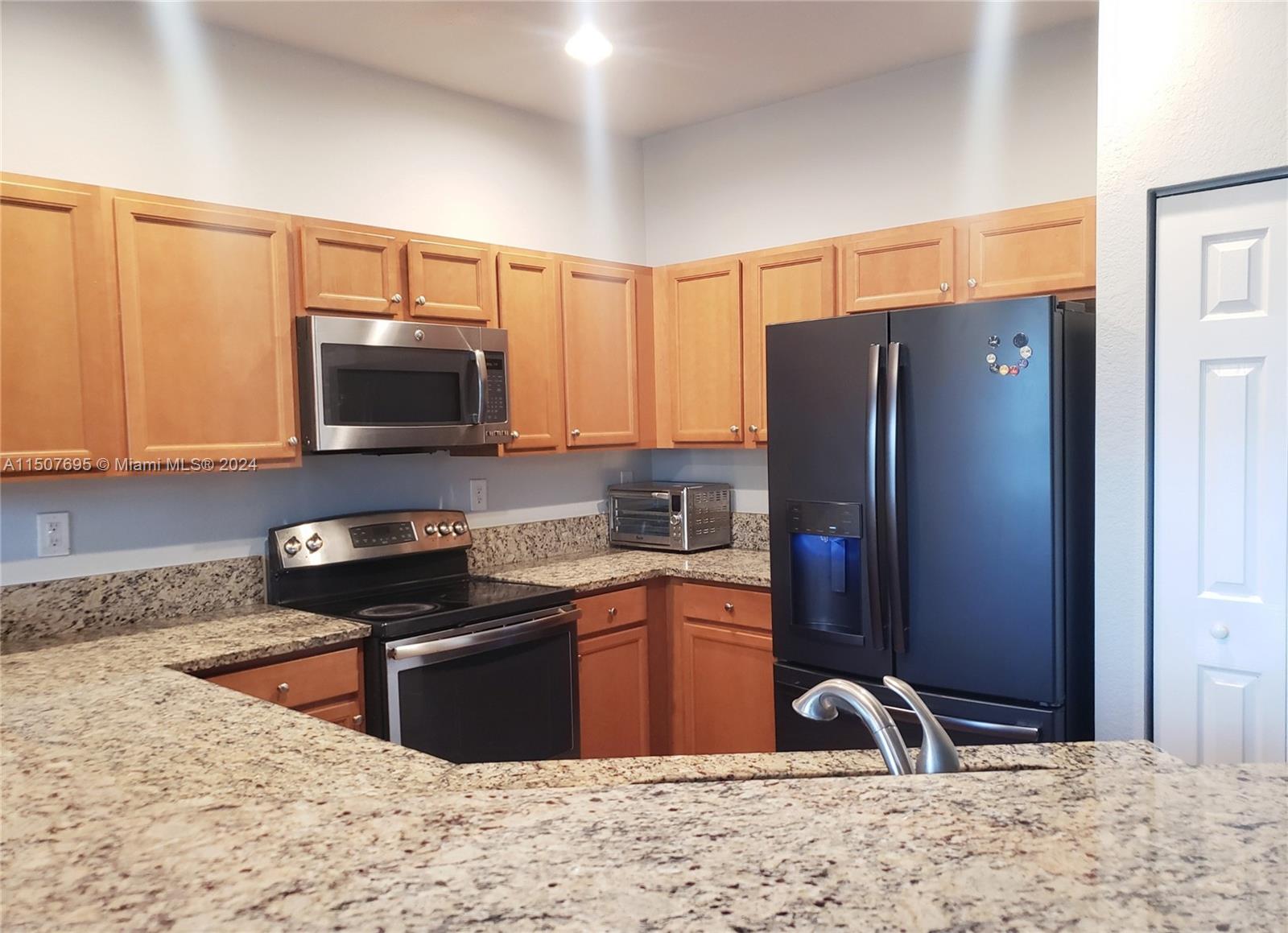 11343 Southwest 232nd Terrace Homestead, FL 33032 - Photo 10 of 35 a kitchen with stainless steel appliances granite countertop a refrigerator stove and sink