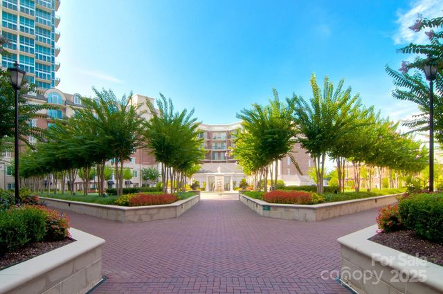 a front view of a house with a garden and palm trees