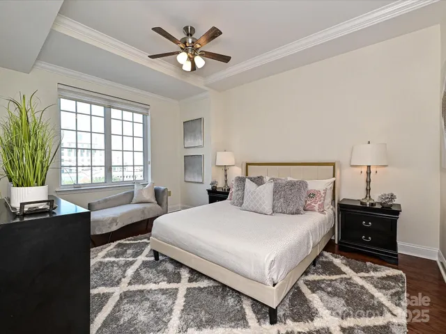 a bedroom with a large bed and a chandelier