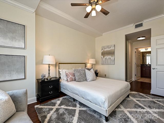 a bedroom with a large bed and a chandelier