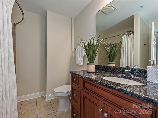 a bathroom with a granite countertop sink a toilet and mirror