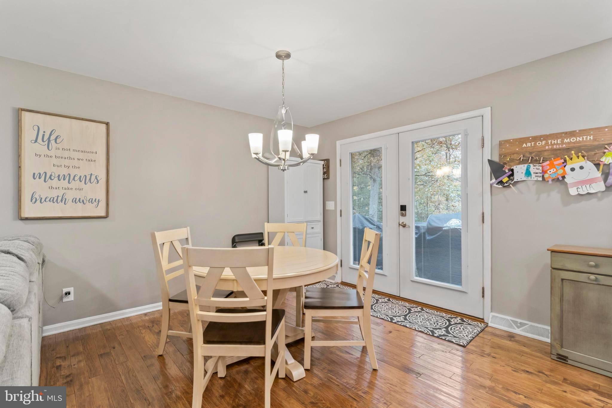 44350 Clarkes Landing Road Hollywood, MD 20636 - Photo 15 of 39 a view of a dining room with furniture a chandelier and wooden floor