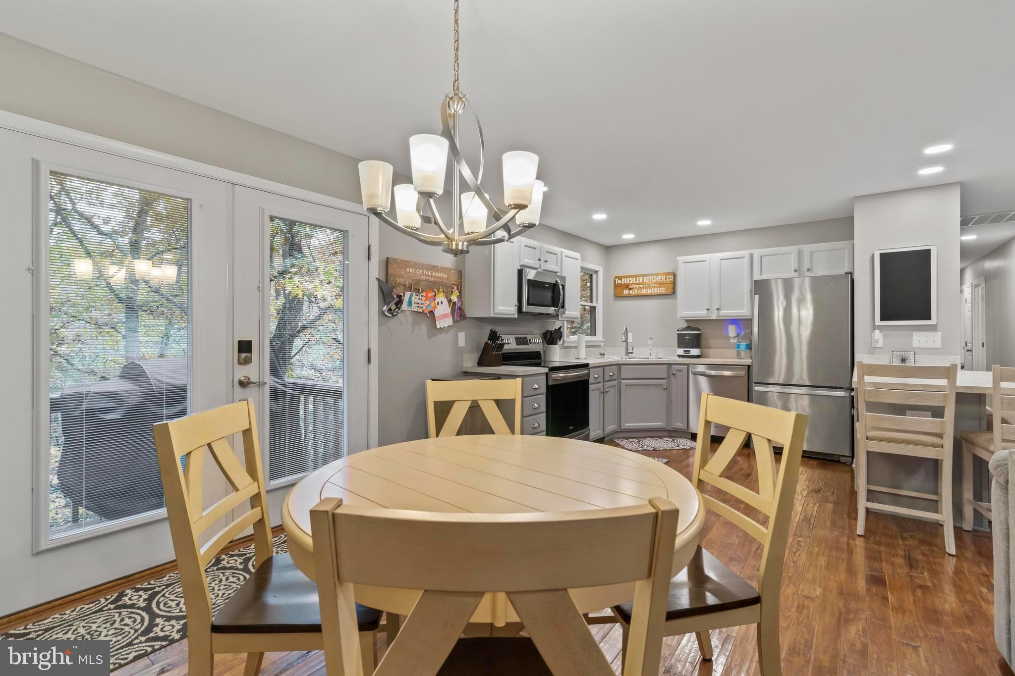 44350 Clarkes Landing Road Hollywood, MD 20636 - Photo 22 of 39 a view of a dining room with furniture a chandelier and wooden floor