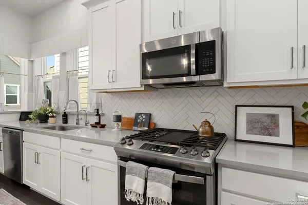 a kitchen with stainless steel appliances a sink a stove and microwave